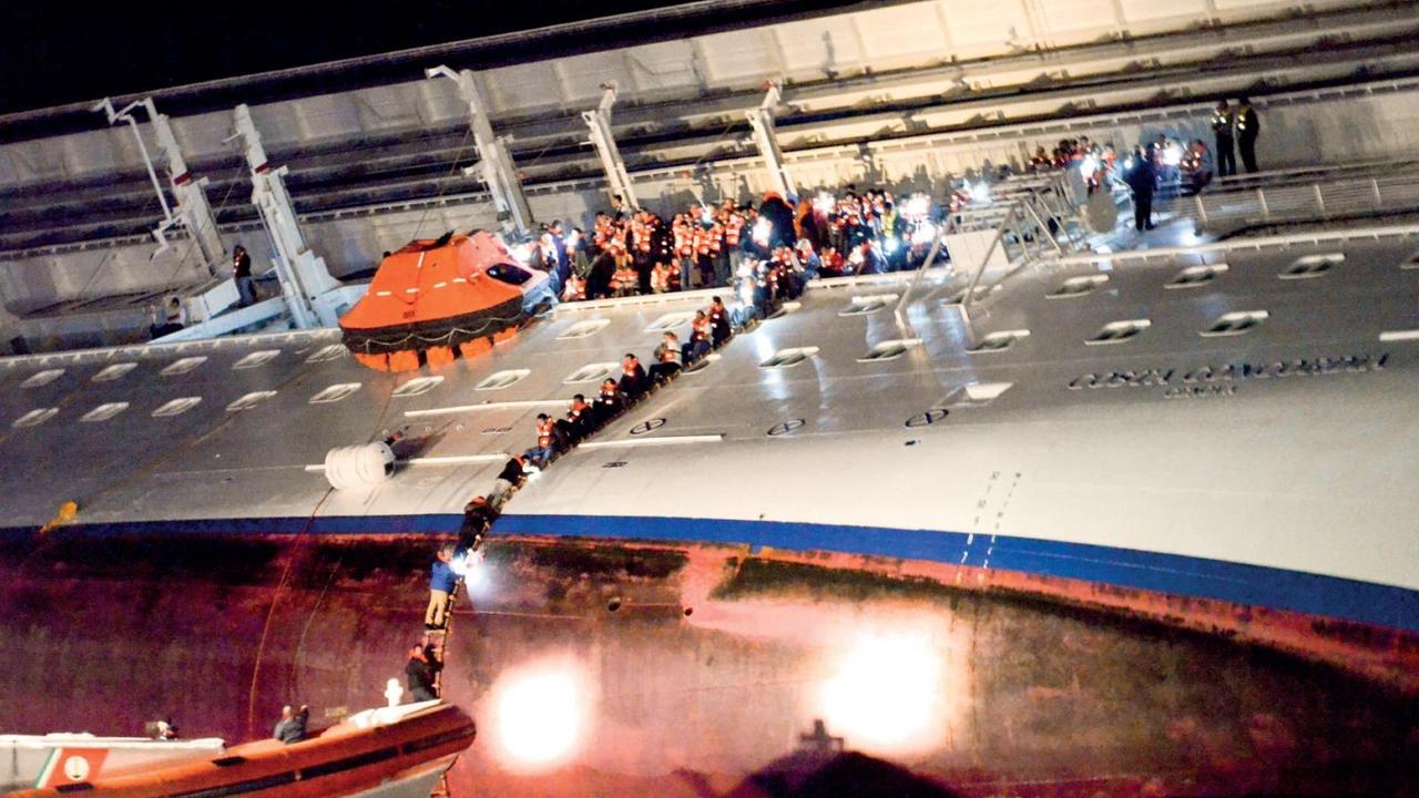 I passeggeri abbandonano la nave usando la biscaggina (foto Massimo Sestini)