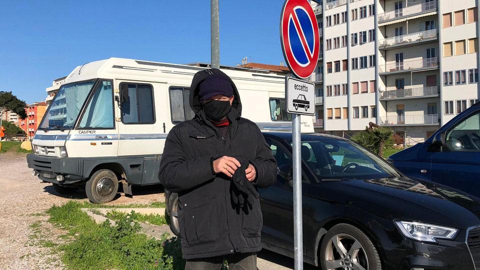 Sebastiano Bortone vicino al suo camper, davanti al cartello di divieto di sosta tranne che per auto