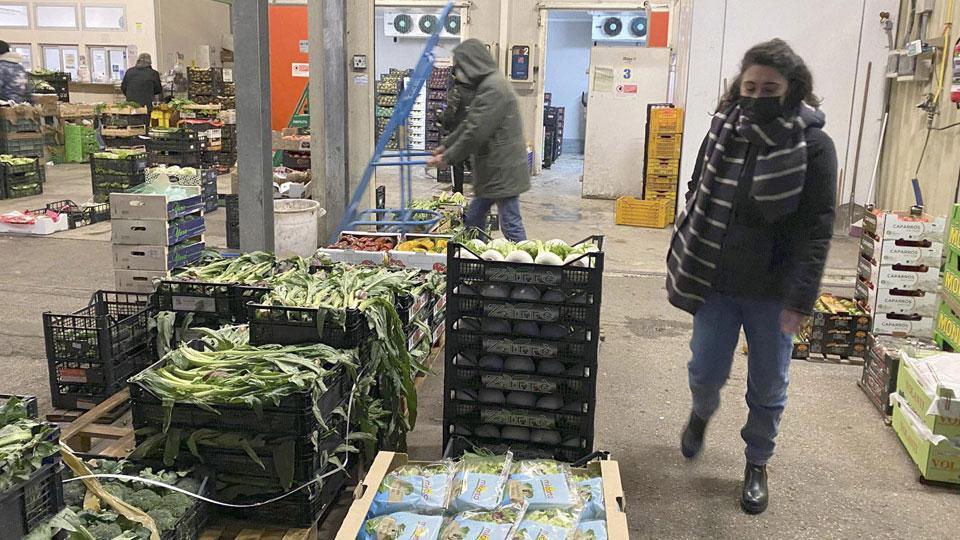 Alcuni operatori al lavoro al mercato della frutta e della verdura (muzzi)