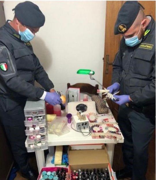 Agenti della guardia di finanza con il materiale sequestrato all’estetista abusiva