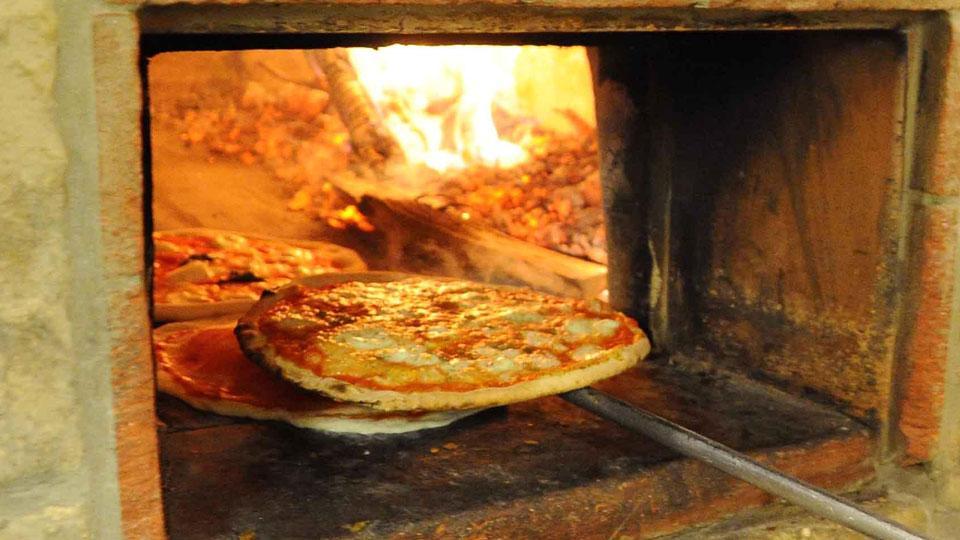 Una pizza esce dal forno: un piatto delizioso che costerà di più in diversi locali della città