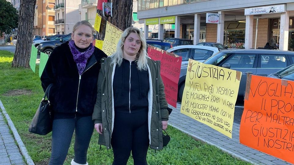 a sinistra, Paulina Jozefiak e Rafaellina Lambardi di fronte ai cartelli affissi davanti all’ingresso del tribunale