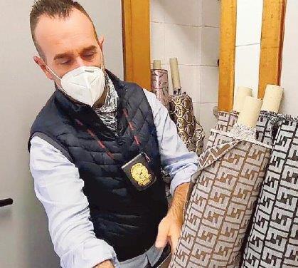 Un finanziere con i tessuti sequestrati nella ditta di Calcinaia
