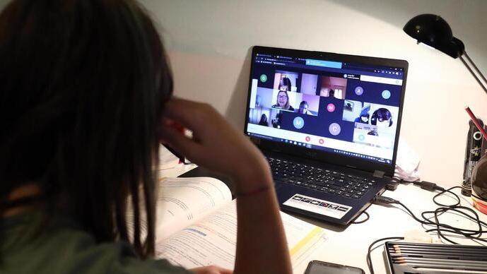 Una studentessa delle scuole superiori segue una lezione davanti al computer in didattica a distanza