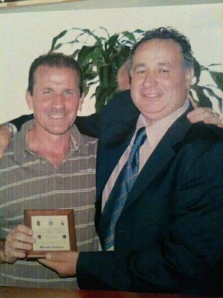 Fabrizio Benemei (a sinistra) mentre viene premiato da Mauro Larini, presidente dei Veterani Sportivi di Orbetello