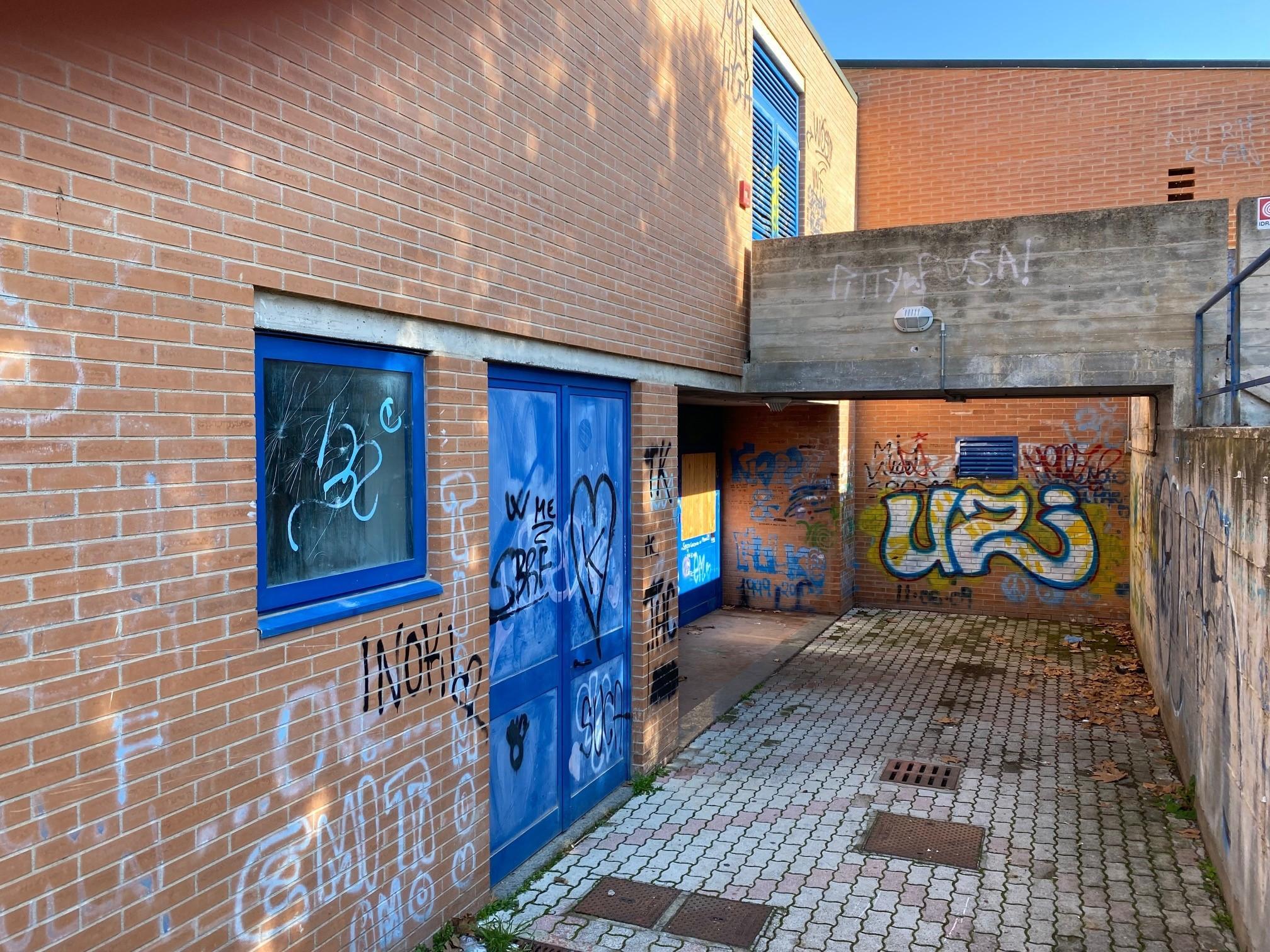 Le scritte e i vetri danneggiati alla scuola