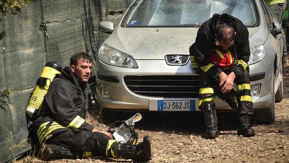 Due vigili del fuoco stremati dalla fatica dopo l’incendio scoppiato a Fiumara il 17 luglio 2017