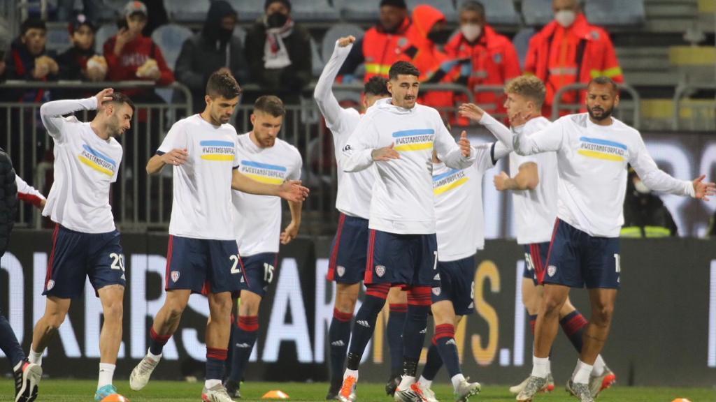 Cagliari, giocatori rossoblù in campo nel pre-partita con i colori dell'Ucraina