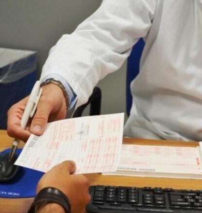 Medico consegna una ricetta al suo paziente in una immagine d’archivio