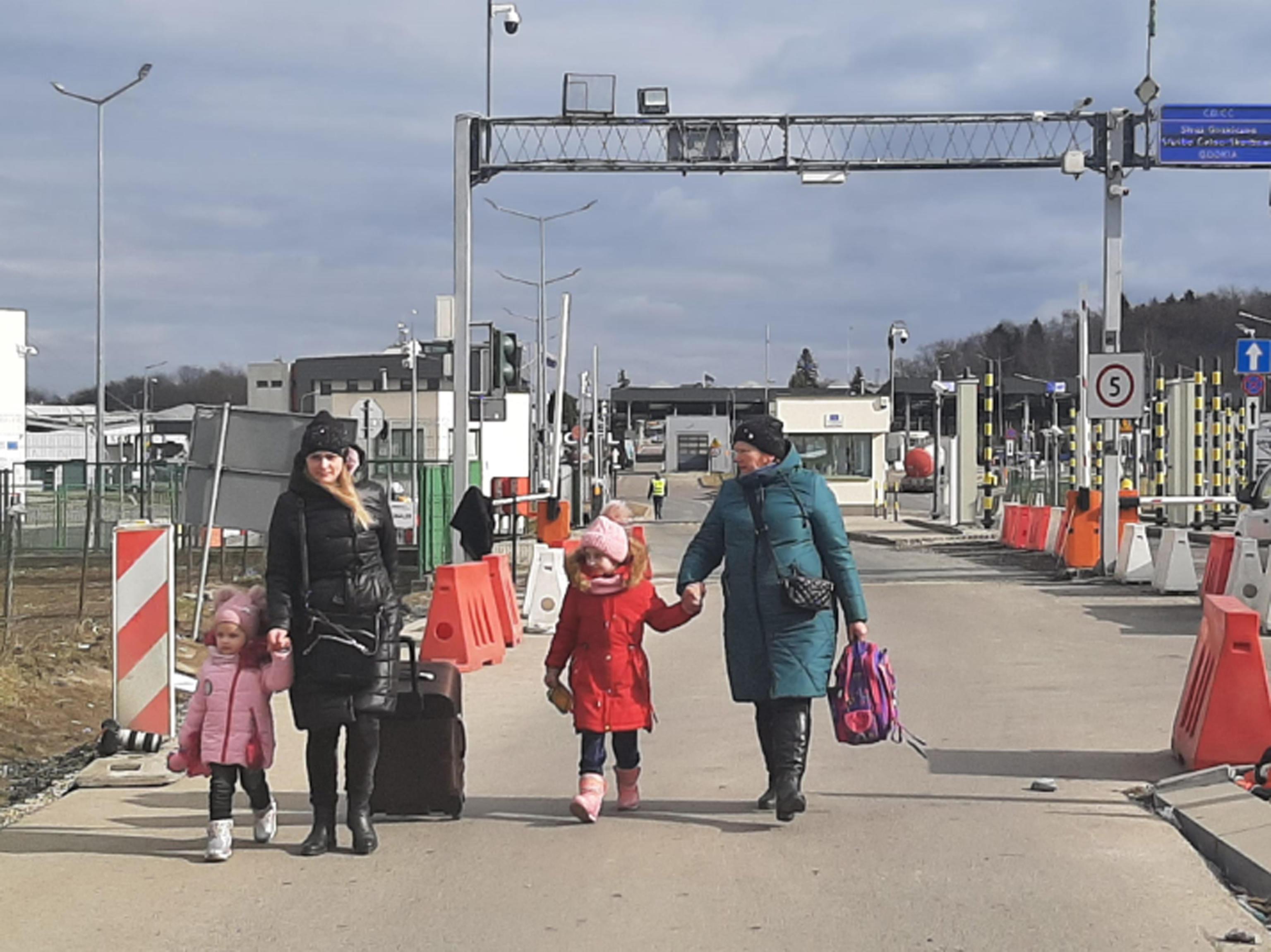 Donne e bambini lasciano l'Ucraina passando dal confine polacco, ormai è una foto simbolo