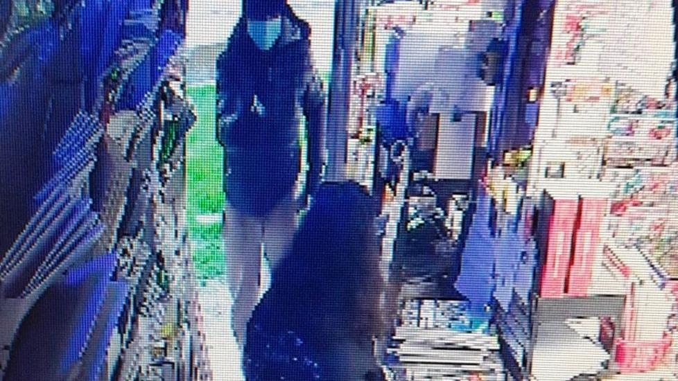 Il rapinatore in azione: pistola in pugno puntata a una commerciante