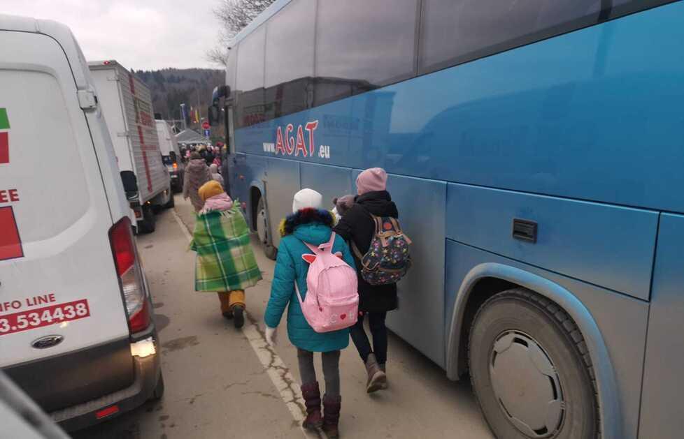 Bambini ucraini con le loro mamme salgono sui pullman per mettersi in salvo oltre il confine