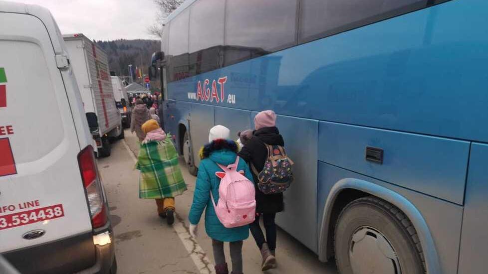 Bambini ucraini con le loro mamme salgono sui pullman per mettersi in salvo oltre il confine
