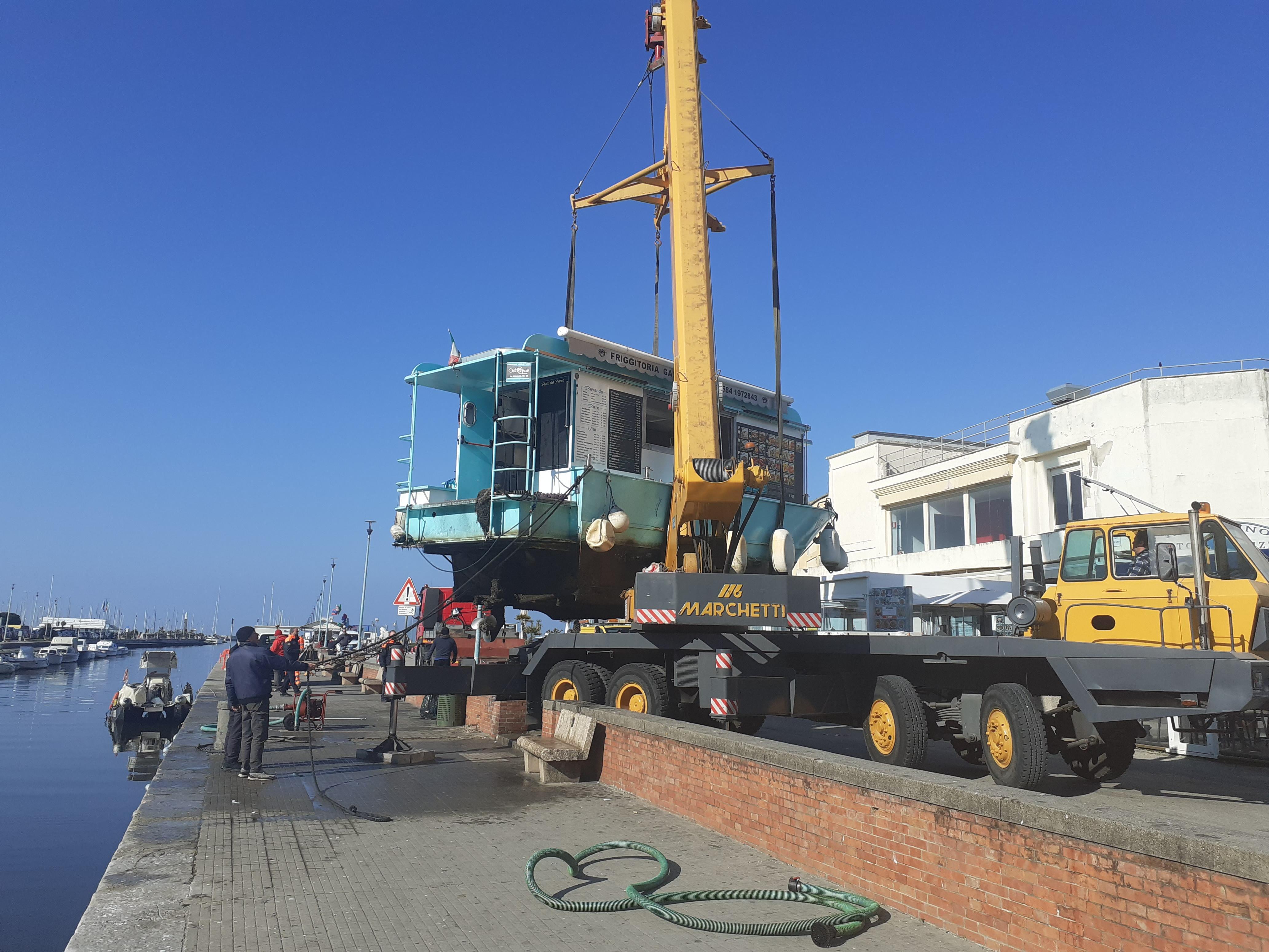 Viareggio, la barca che vende il fritto lungo il canale rischia di affondare per colpa delle reti