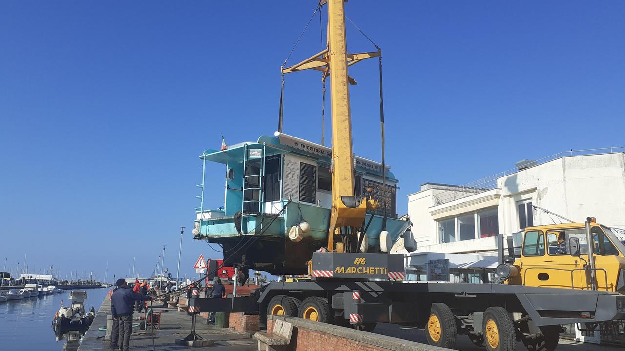 Viareggio, la barca che vende il fritto lungo il canale rischia di affondare per colpa delle reti