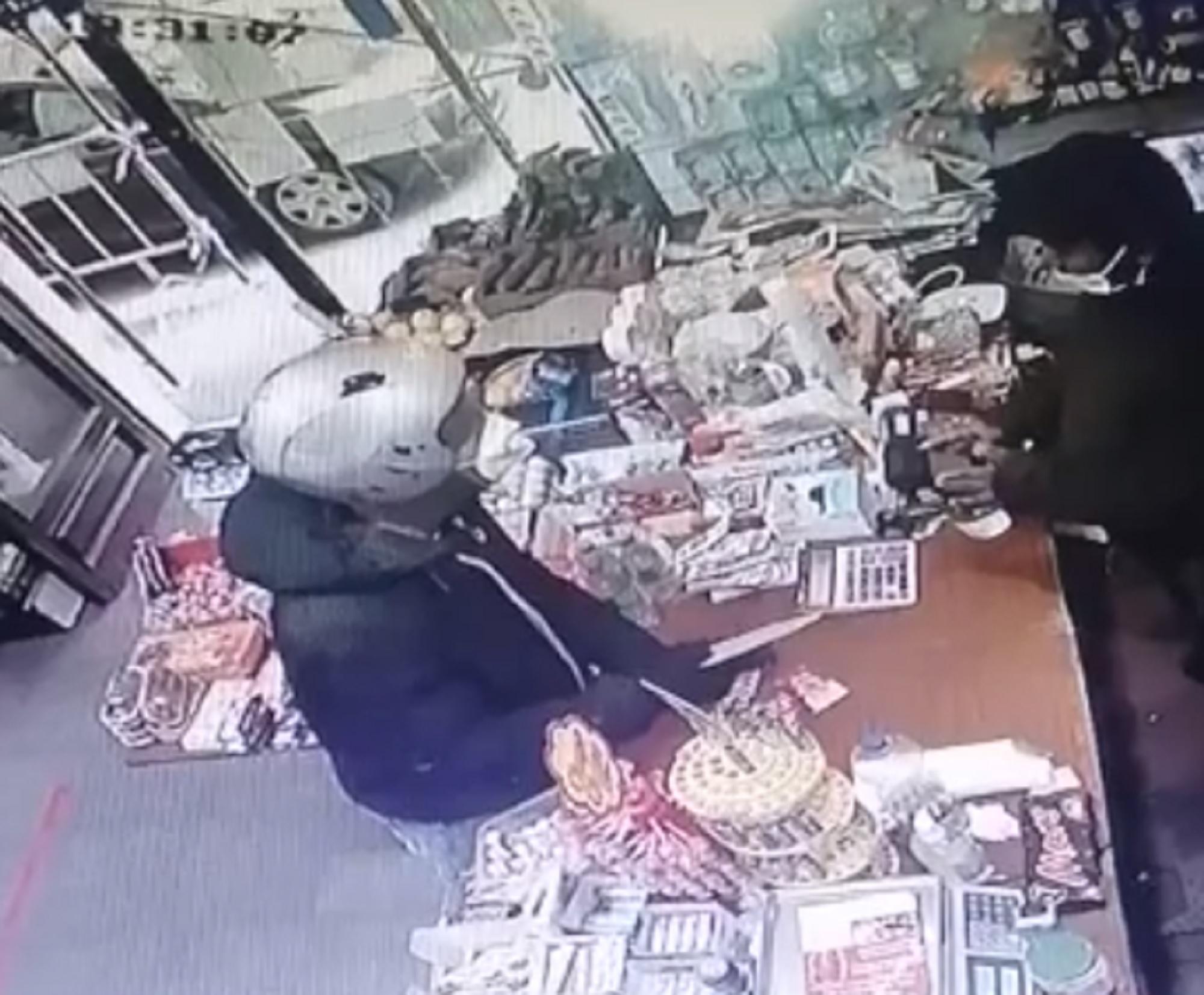 Il rapinatore mentre punta il coltello contro il dipendente
