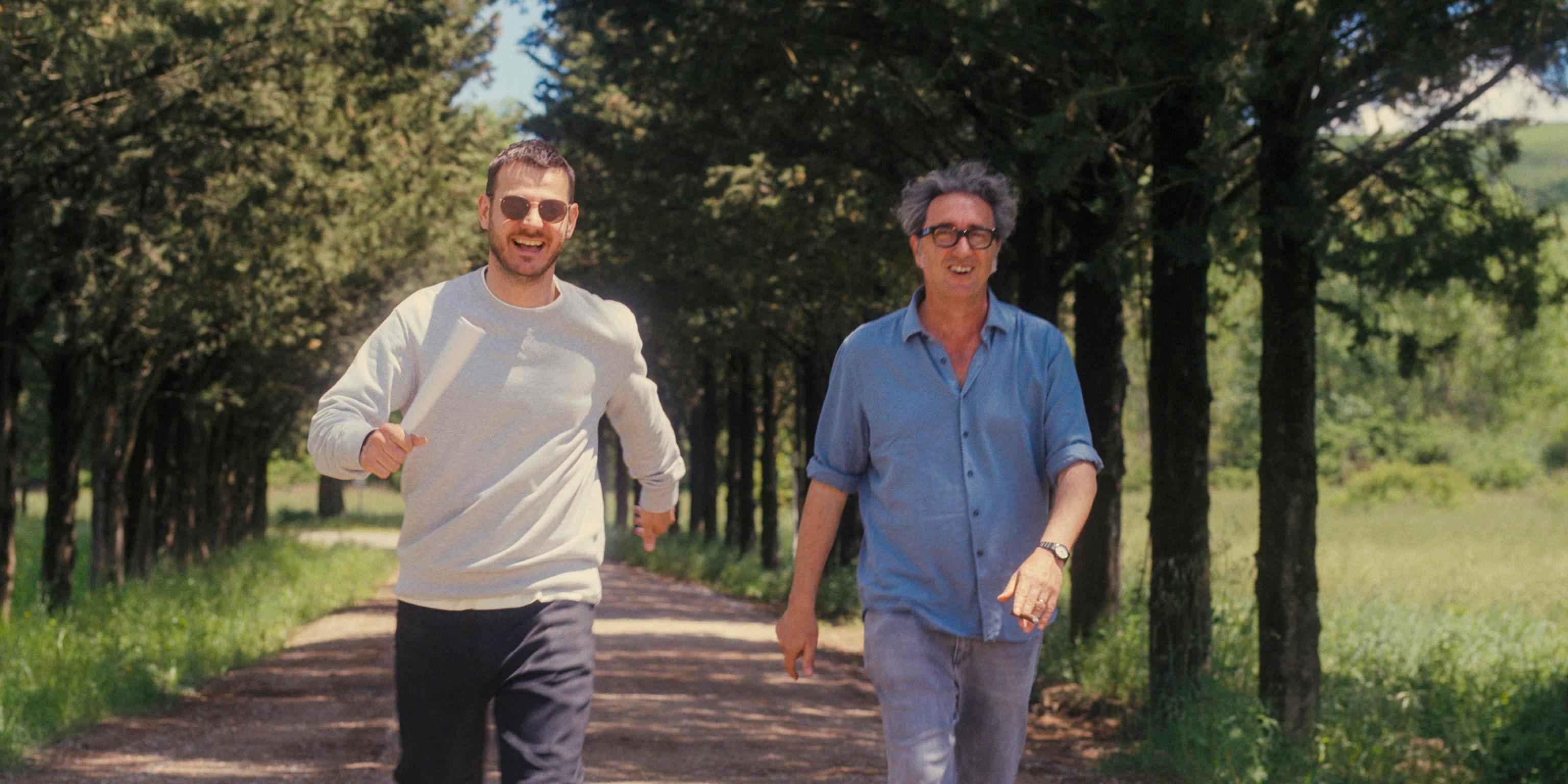 Alessandro Cattelan con Paolo Sorrentino in una scenda del film e sotto l’autore in galleria Duomo a Milano