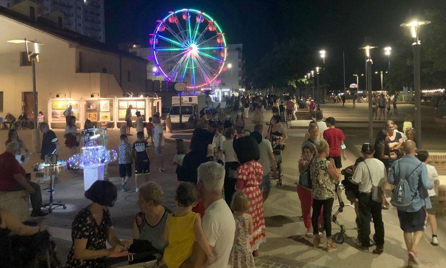 Il viale Italia affollato di turisti e la ruota panoramica