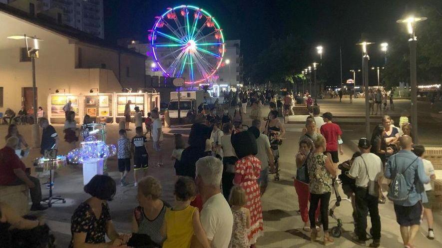 Il viale Italia affollato di turisti e la ruota panoramica