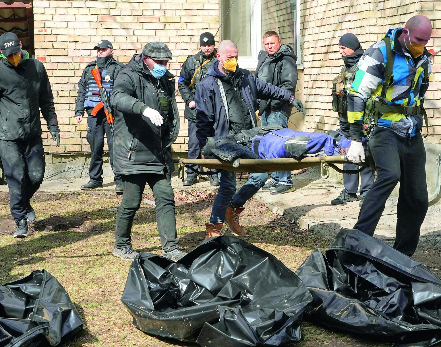 Soldati e cittadini rimuovono i cadaveri dalle strade e dalle case di Bucha