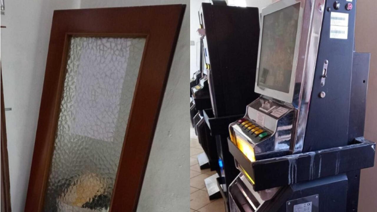 A sinistra la porta scardinata. A destra una slot machine imbrattata