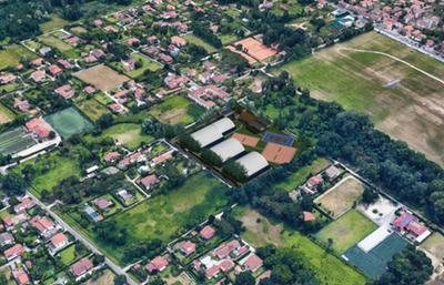 Al centro della fotografia il rendering del centro polisportivo, come da progetto