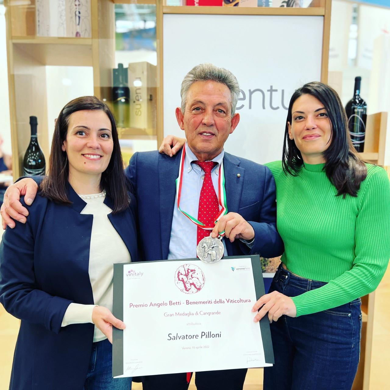 Salvatore Pilloni mostra con le figlie il premio ricevuto al Vinitaly