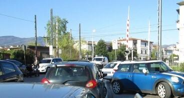 Auto parcheggiate a ridosso del passaggio a livello della ferrovia Porrettana