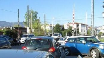 Auto parcheggiate a ridosso del passaggio a livello della ferrovia Porrettana