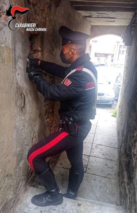 I carabinieri davanti al “buco” nel muro da cui passava la cocaina