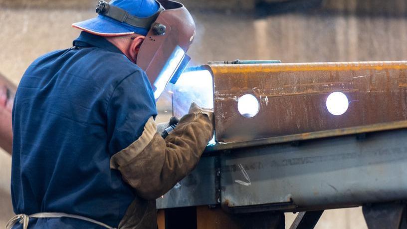Un operaio impegnato nella saldatura di profilati metallici (foto d’archivio)
