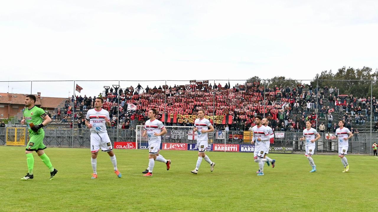 La Lucchese al momento dell'ingresso in campo a Gubbio, nello spareggio playoff poi perso 1-0: sullo sfondo il calore dei 750 tifosi rossoneri in Umbria