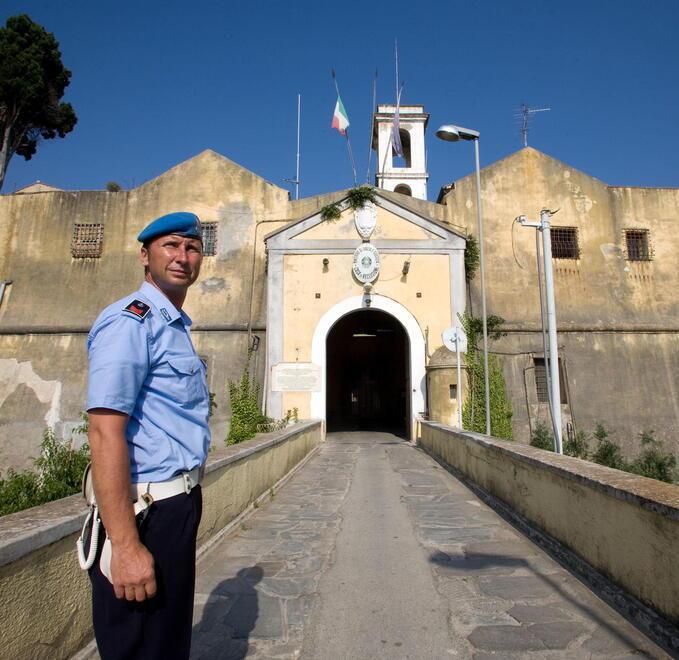 Un agente di polizia penitenziaria davanti all’ingresso del carcere di Porto Azzurro