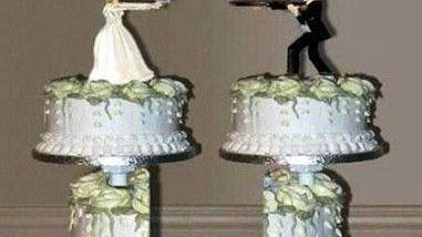 Una torta nuziale con gli sposi che si puntano le armi (foto d’archivio)