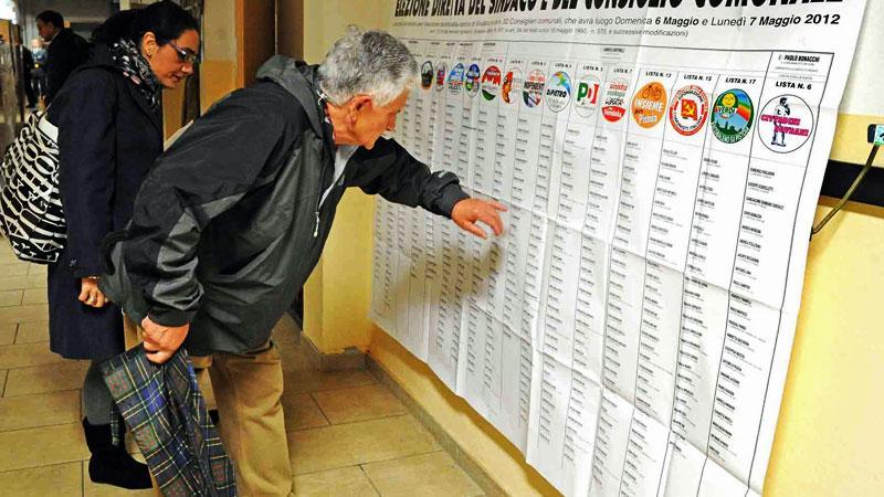 Elettori consultano l’elenco dei candidati al consiglio comunale (archivio)