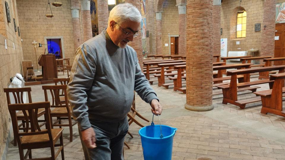 Don Marcello mentre raccoglie l’acqua in chiesa (foto enzo Russo)