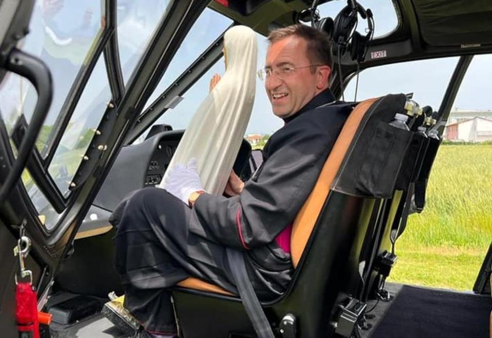 Monsignor Andrea Migliavacca in una immagine inconsueta a bordo di un elicottero che portava in giro per la Diocesi la statua della Madonna di Fatima