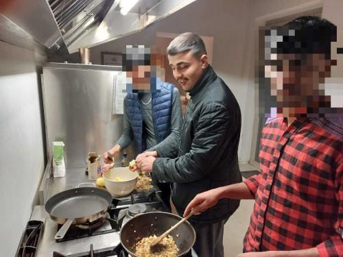 lyas El Hicou insieme a due compagni nella cucina della comunità