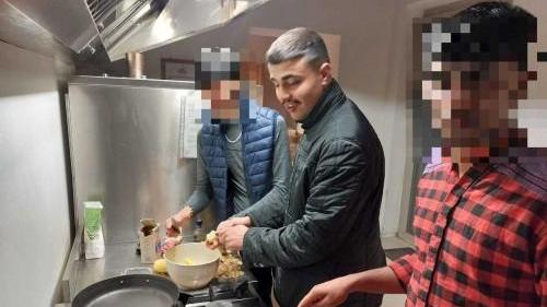 lyas El Hicou insieme a due compagni nella cucina della comunità