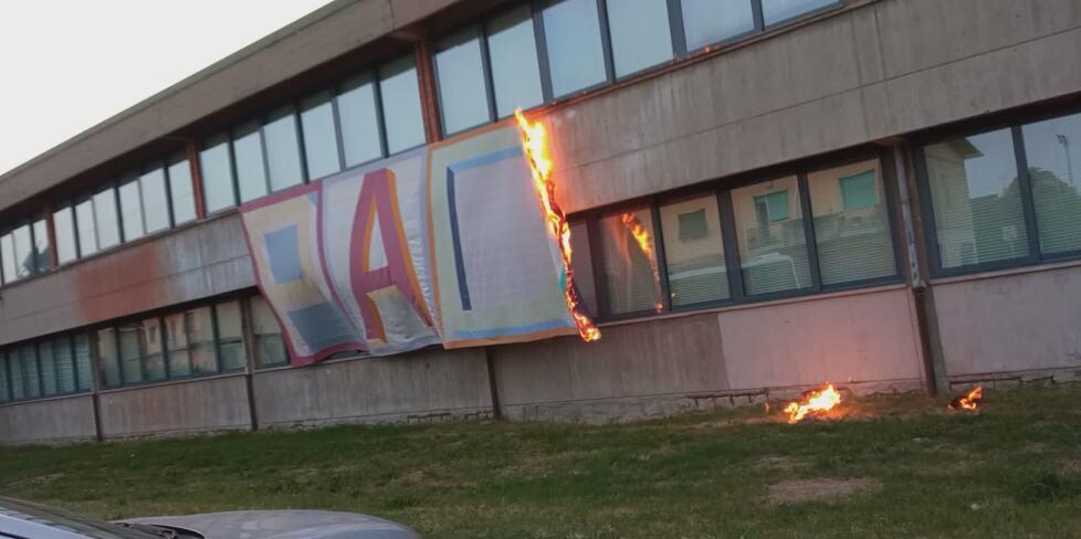 Lo striscione in fiamme sulla facciata della scuola