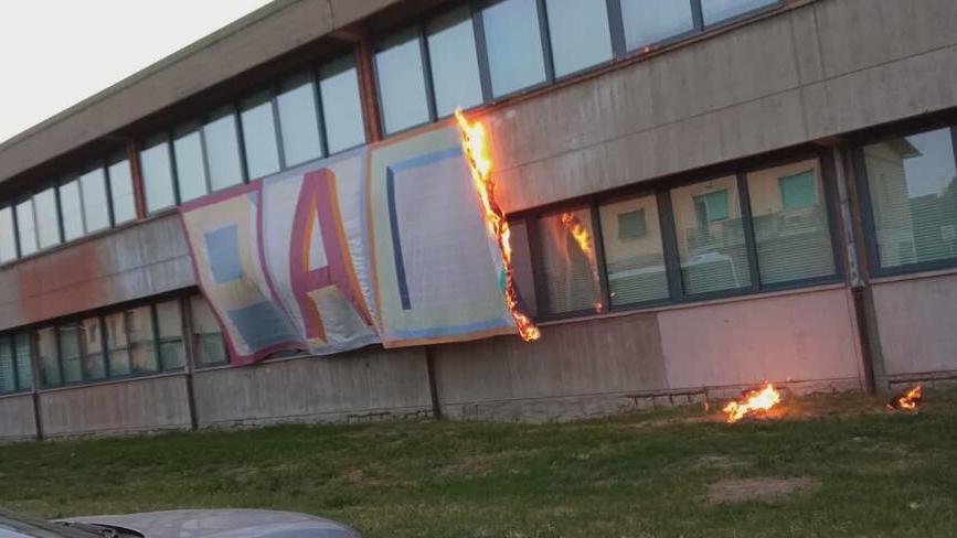 Lo striscione in fiamme sulla facciata della scuola
