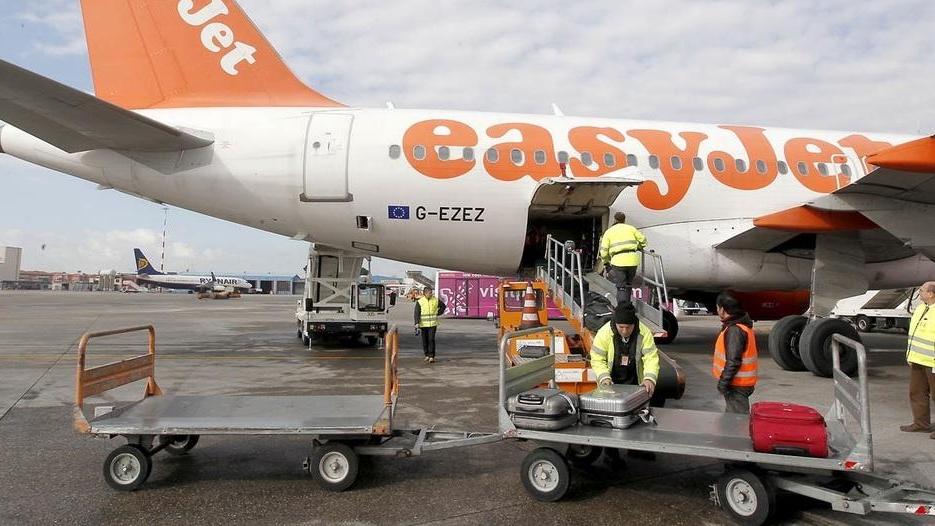 L’imbarco dei bagagli a bordo di un aereo che sta per partire da Pisa, aeroporto Galilei (foto Muzzi)