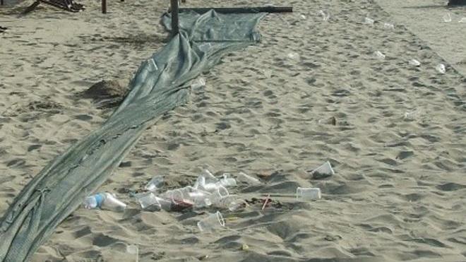 Spiaggia sporca dopo la mega-festa