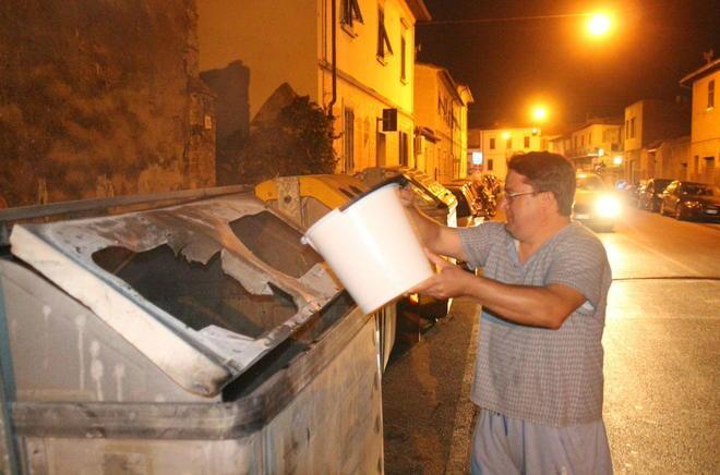 I cittadini spengono il rogo del piromane dei cassonetti 
