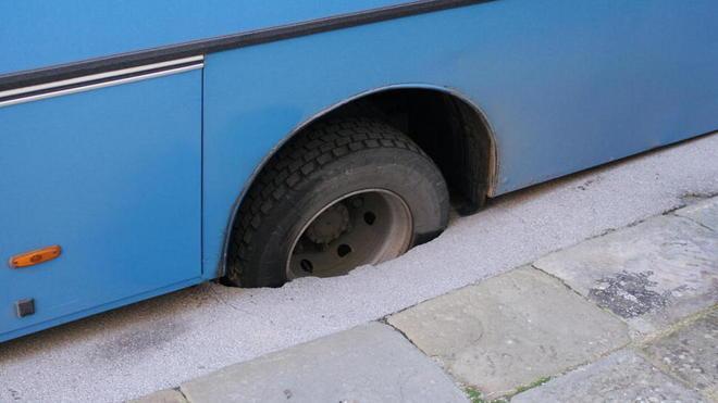 Si apre una voragine in piazza e il bus ci finisce con la ruota