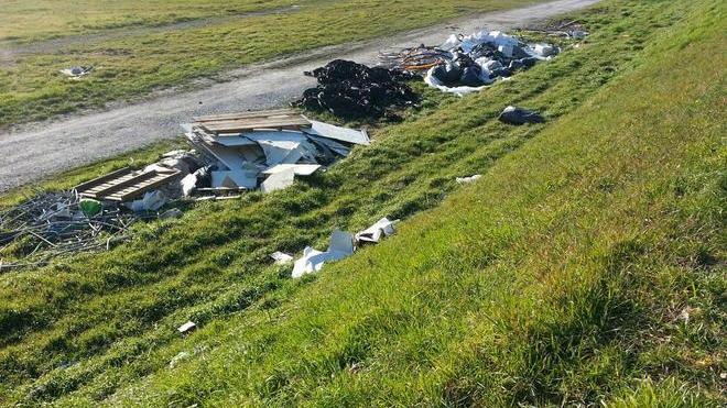 Discarica a cielo aperto lungo la pista ciclabile a Mezzana