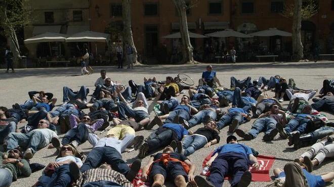 Sdraiati in piazza contro i licenziamenti