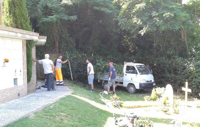 Cittadini al lavoro dentro al cimitero 