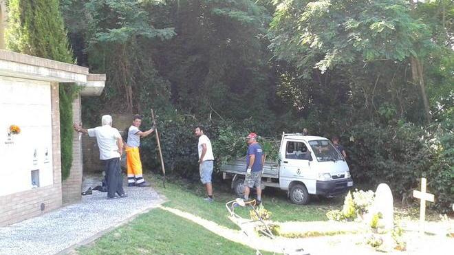 Cittadini al lavoro dentro al cimitero