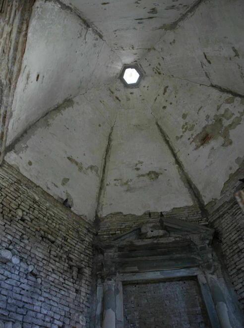 Un piccolo tempio invaso da piccioni e piante infestanti 